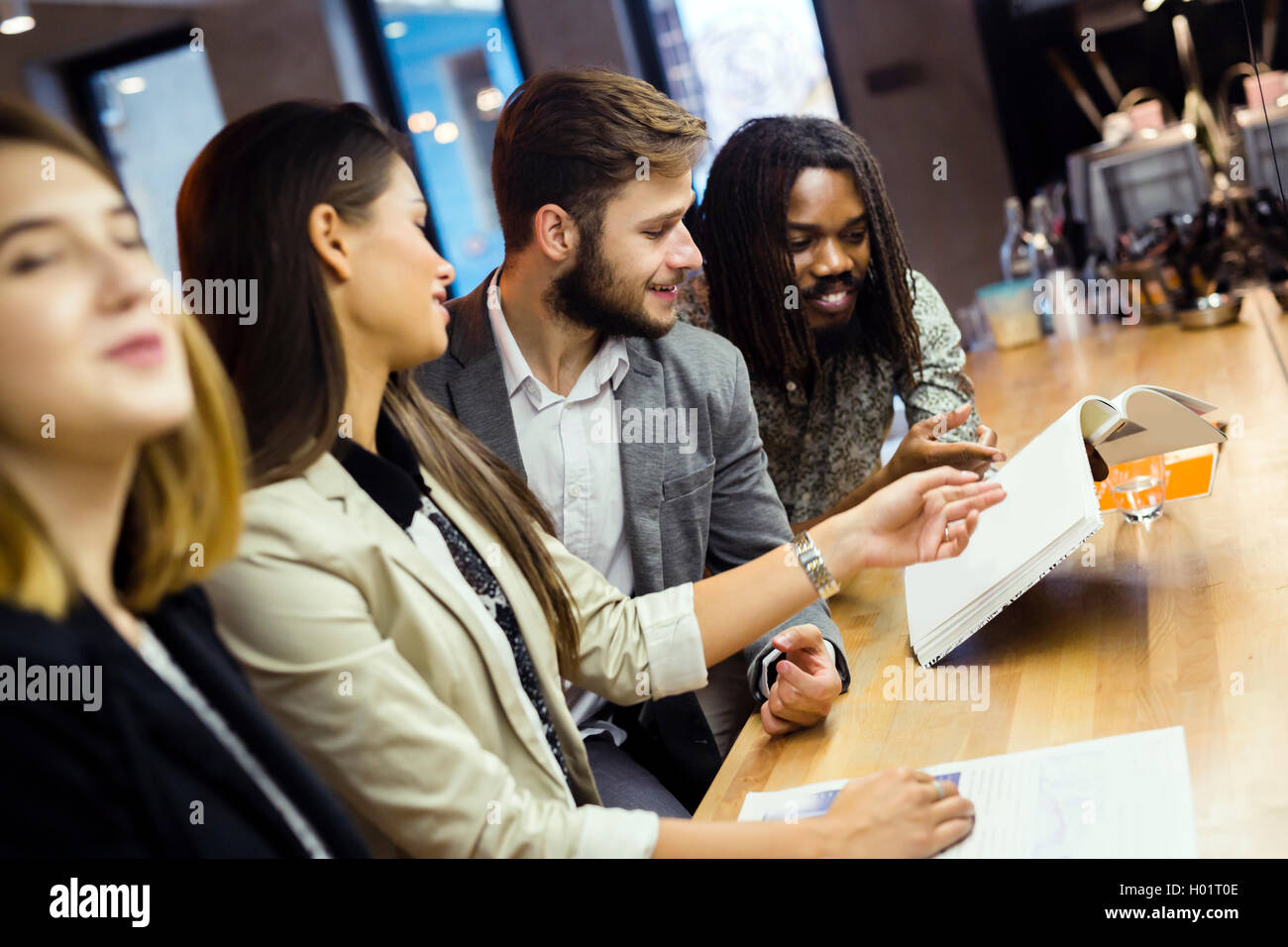 Gruppe von Menschen, die Diskussion über den Inhalt des Artikels beim Sitzen in einer bar Stockfoto