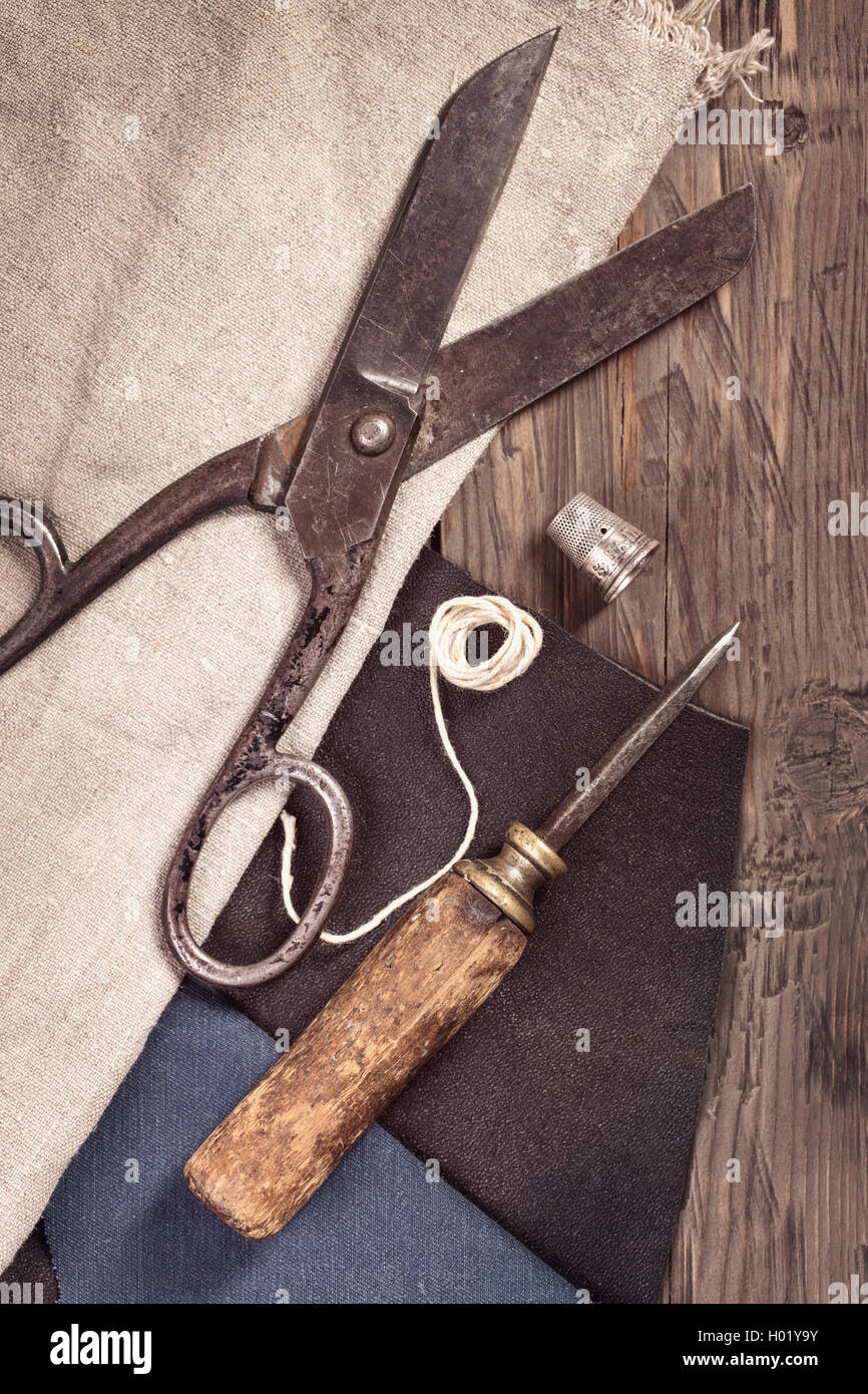 Vintage Schere, Ahle und Fingerhut mit Leder und Stoff Stockfoto