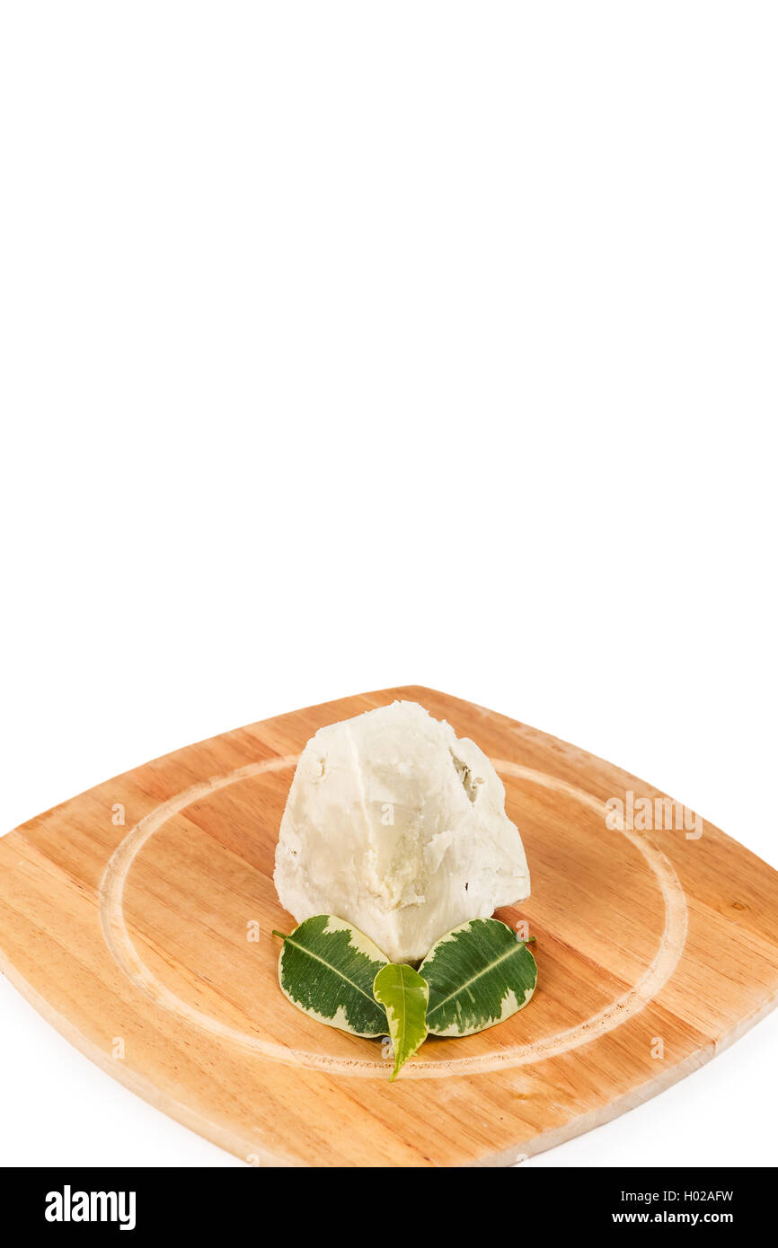 Unraffiniertes, organische Shea Butter mit grünen Blättern auf dem Holzbrett auf dem weißen Hintergrund. Stockfoto