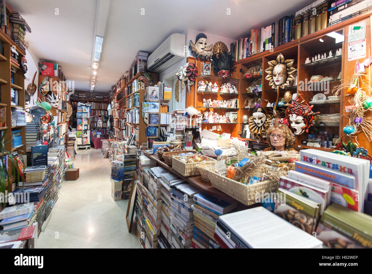 DUBROVNIK, Kroatien - 28. Mai 2014: Umsatz Frau sitzt am Tresen in der Buchhandlung. Stockfoto