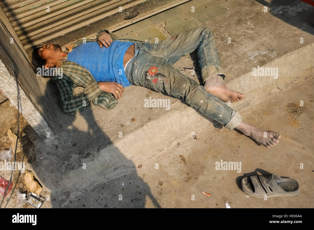 JODHPUR, Indien - 10. Februar 2015: betrunken indischen Mann ohnmächtig auf Straße mit Fotografen Schatten. Stockfoto