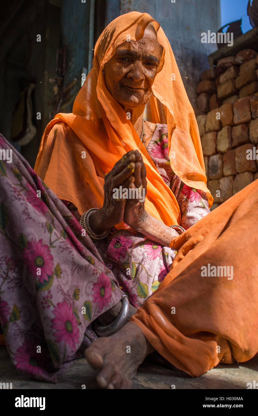 GODWAR REGION, Indien - 13. Februar 2015: ältere indische Frau in Sari mit überdachten Kopf sitzt in der Tür des Hauses. Stockfoto