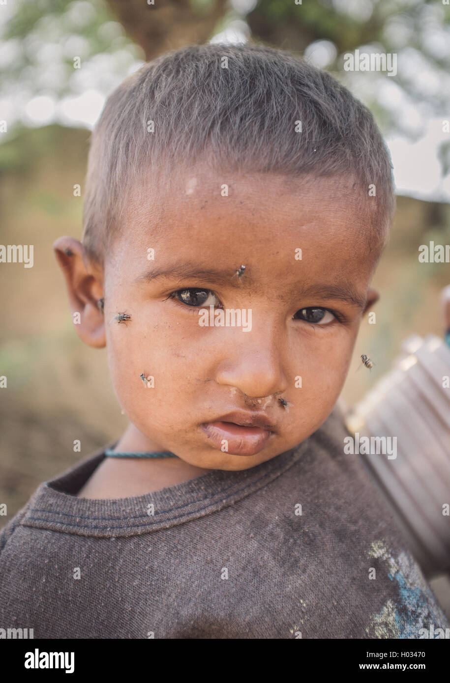 GODWAR REGION, Indien - 15. Februar 2015: junge indische Kind mit Gesicht fliegt. Nachbearbeitet mit Getreide, Textur und colou Stockfoto