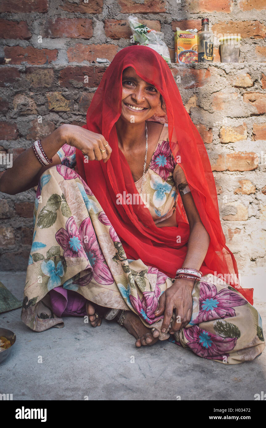 GODWAR REGION, Indien - 13. Februar 2015: indische Frau in Sari sitzt neben Ziegelwand. Nachbearbeitet mit Getreide, Textur und co Stockfoto