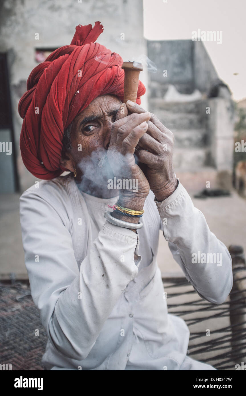 GODWAR REGION, Indien - 12. Februar 2015: Rabari Stammesangehörige raucht Chillum. Nachbearbeitet mit Getreide, Textur und Farbe-Effekt. Stockfoto