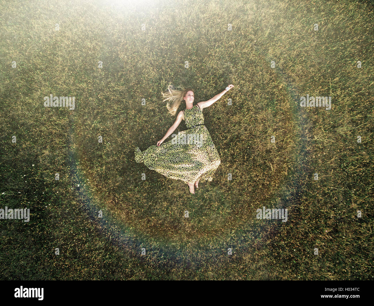 Luftaufnahme der junge Frau in einem grünen Kleid legen Sie sich auf eine Wiese. Post mit Polaroid-Filter verarbeitet. Stockfoto