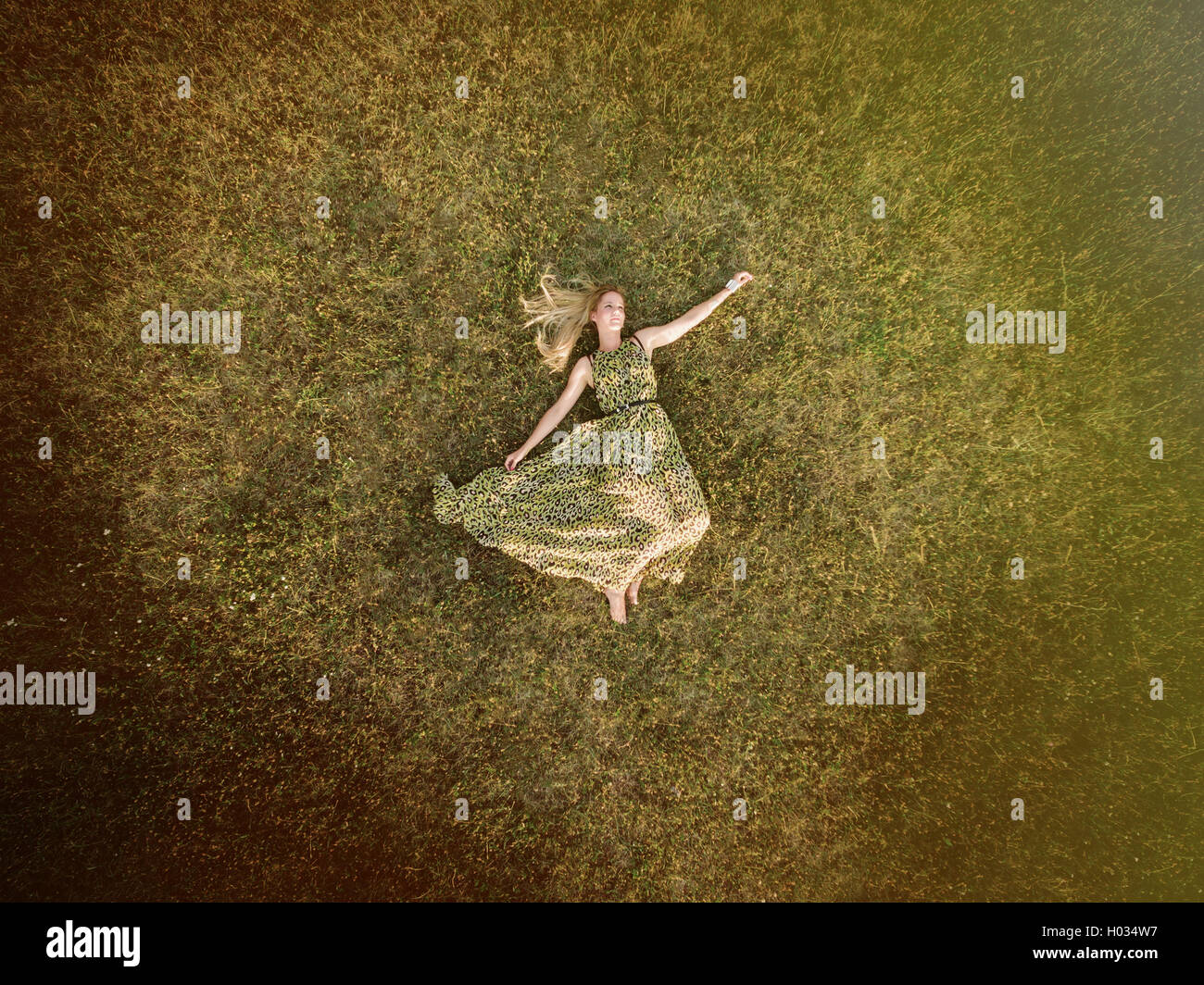 Luftaufnahme der junge Frau in einem grünen Kleid legen Sie sich auf eine Wiese. Post mit Vintage-Filter verarbeitet. Stockfoto
