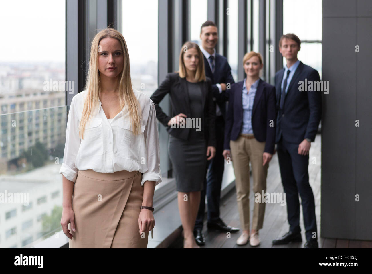 Unternehmensportrait der junge Geschäftsfrau mit ihren Kollegen im Hintergrund. Stockfoto