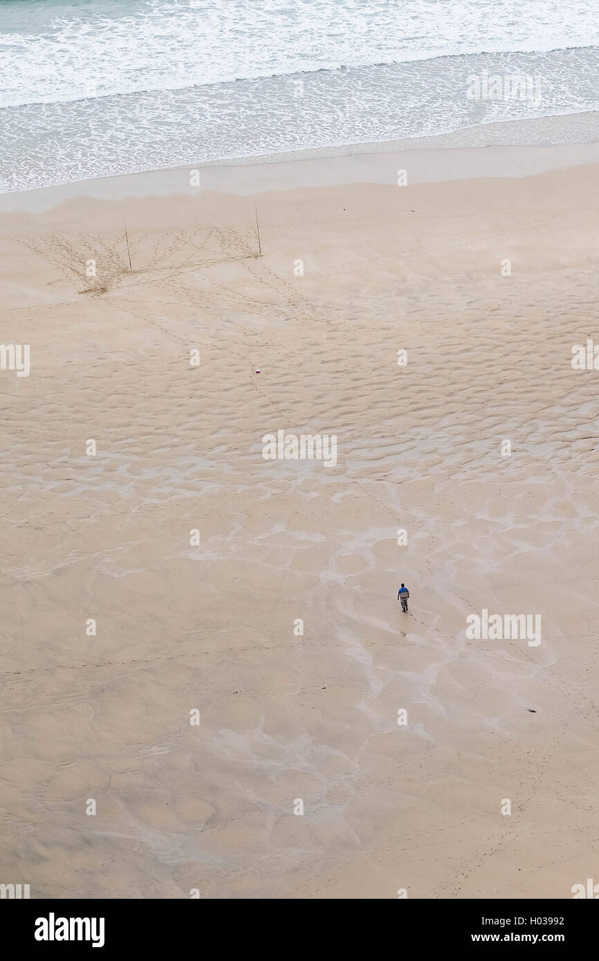 Ein Blick von oben auf ein Angler an einem Strand in Cornwall. Stockfoto