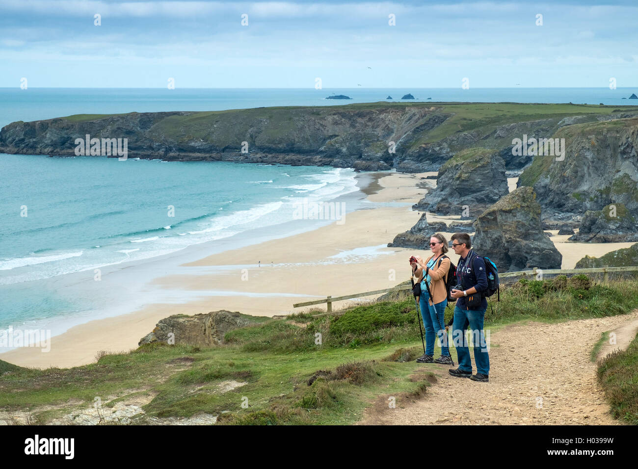 Wanderer auf dem South West Coastal Path ruhen und genießen Sie die spektakuläre Aussicht auf Carnewas bei Bedruthan in Cornwall. Stockfoto