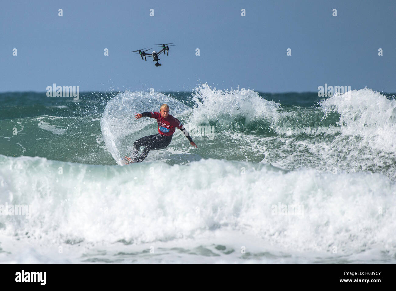 Eine Drohne filmt ein Konkurrent in Aktion bei der GB Inter Clubs Surfen Surfwettbewerb am Fistral in Newquay, Cornwall. VEREINIGTES KÖNIGREICH. Stockfoto