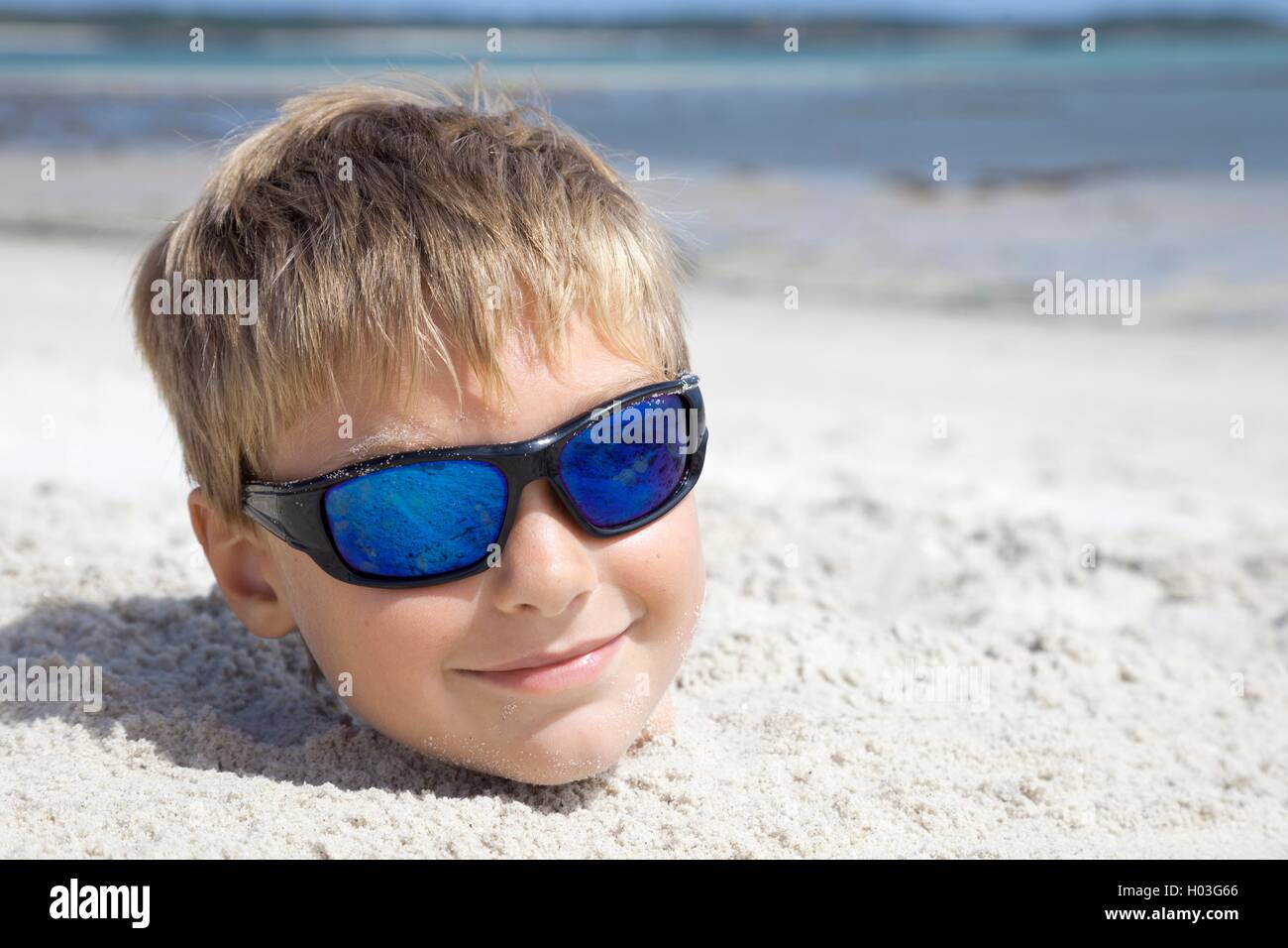Junge im Urlaub im Sand vergraben Stockfoto