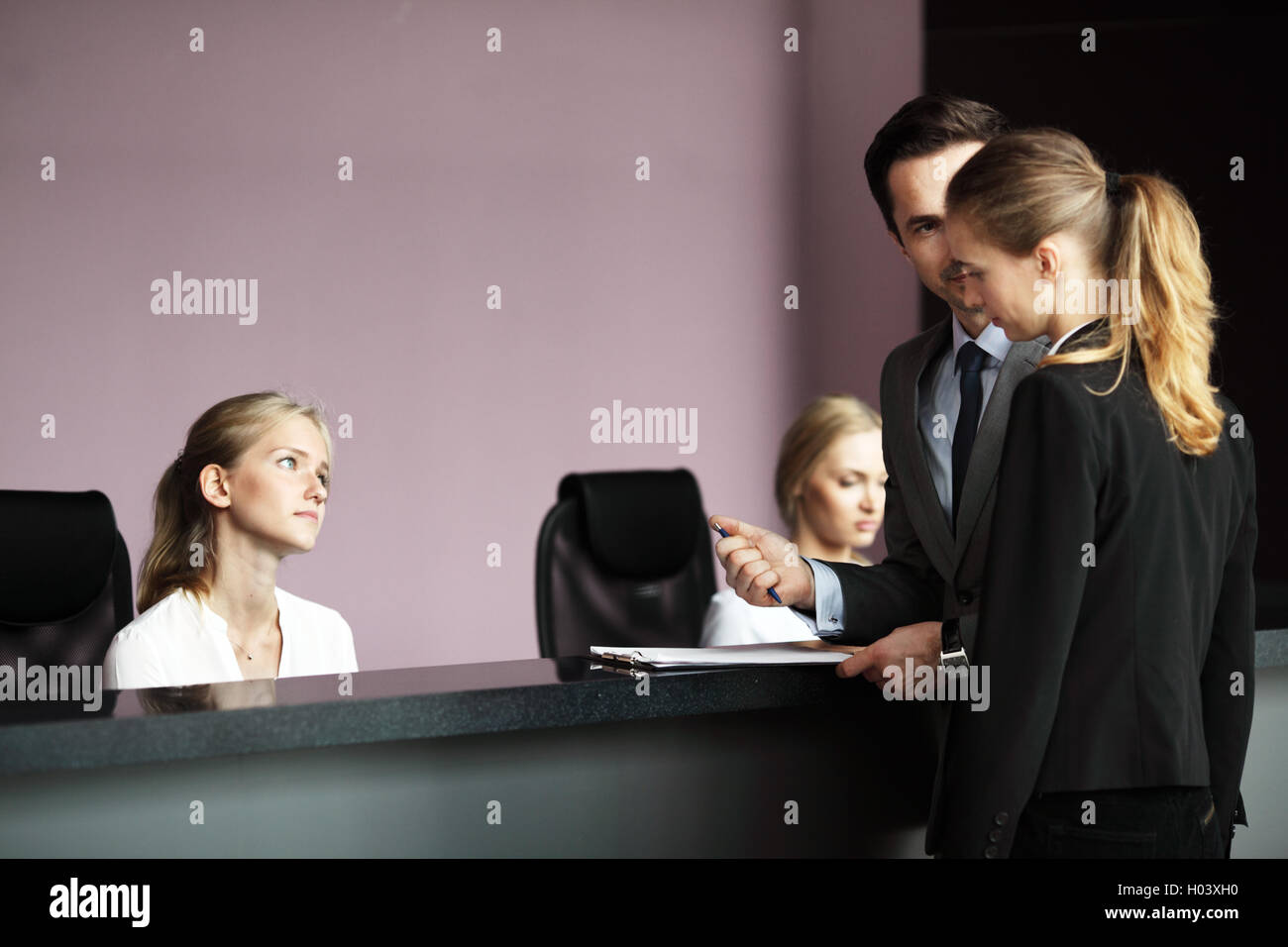 Geschäftsleute, Ausfüllen von Formularen an der Rezeption Stockfoto