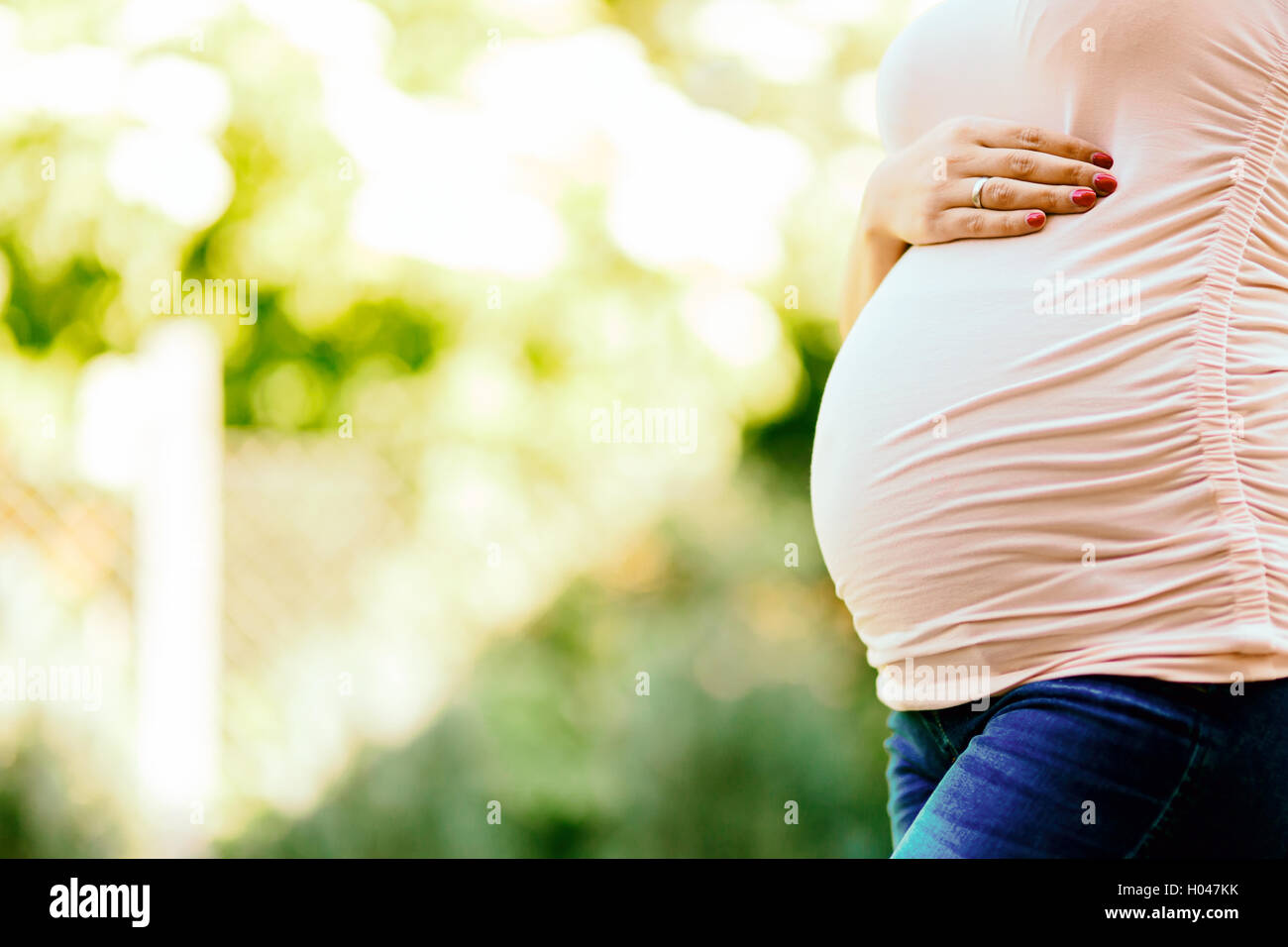 Schöne schwangere Frau Bauch im Freien halten Stockfoto