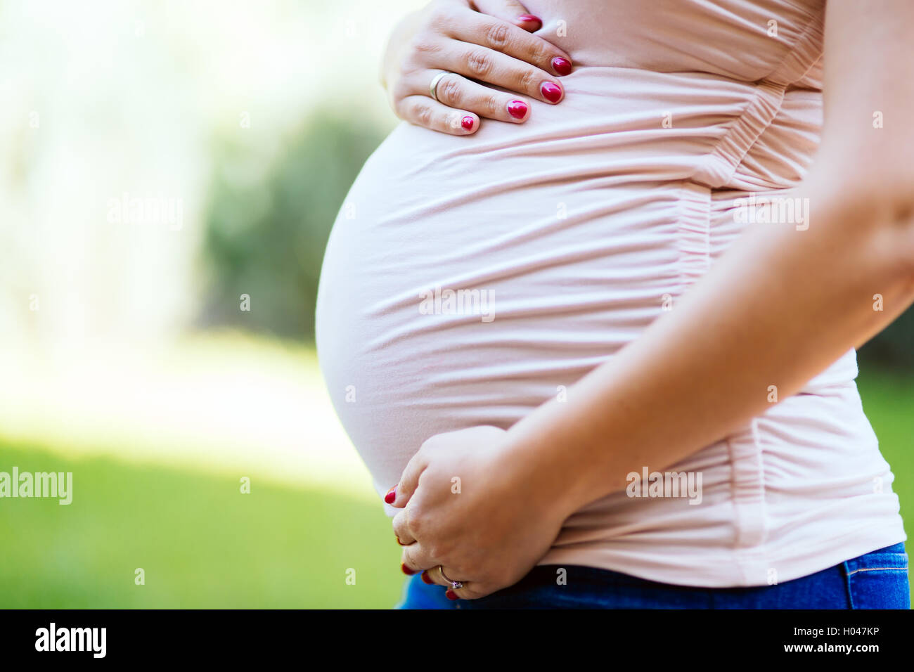 Schöne schwangere Frau Bauch im Freien halten Stockfoto