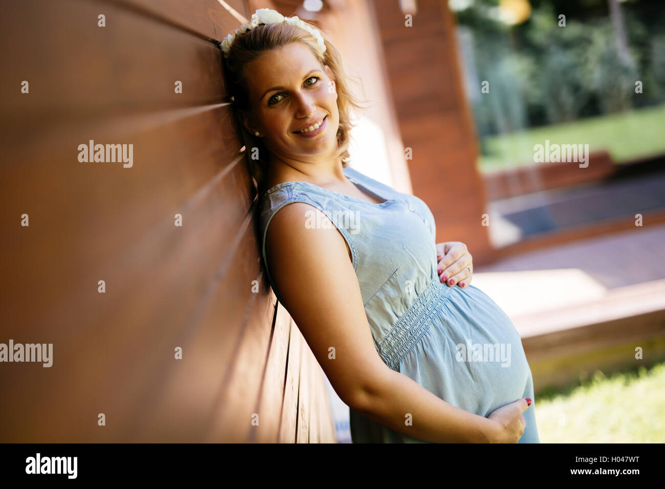 Schöne blonde schwangere Frau hält ihren Bauch Stockfoto