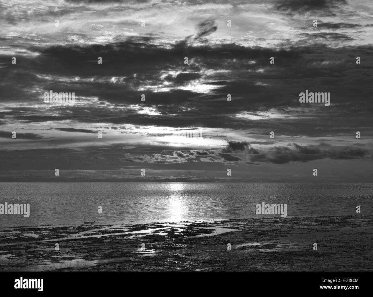 Schwere Wolken bei Sonnenuntergang an einem Strand in Florida. Stockfoto