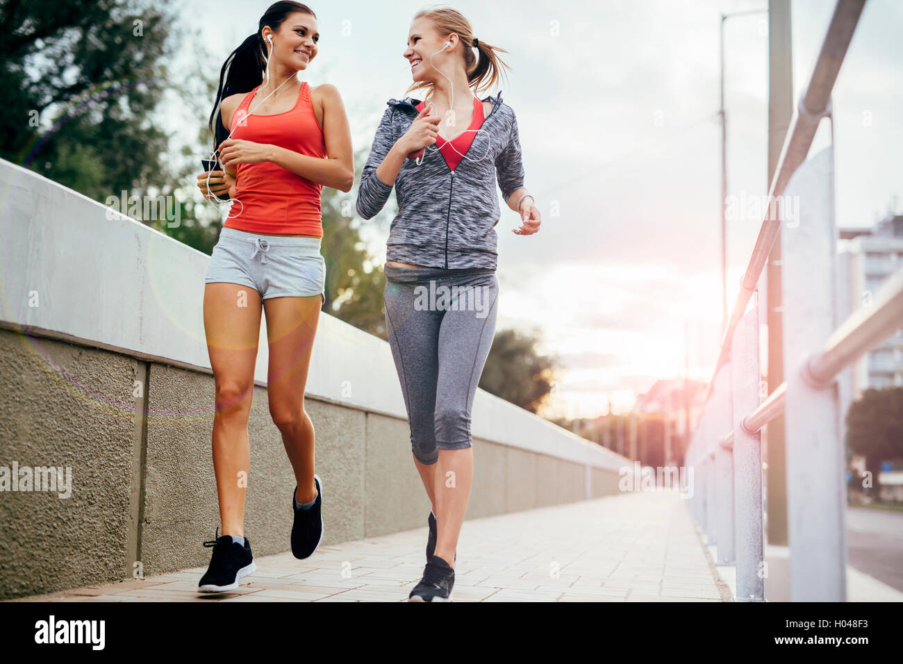 Schöne Landschaft von zwei weiblichen Jogger verfolgt ihre Aktivitäten im Freien in der Stadt in der Dämmerung Stockfoto