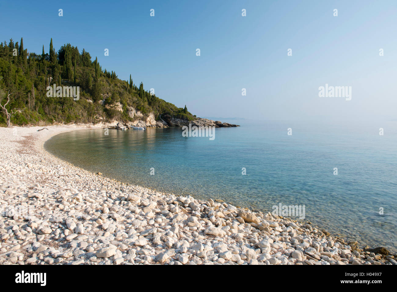 Runden Sie Steinen und dem klaren Sie Meer auf Orkos Beach an der Ostküste von Paxos, die Ionische Inseln, Griechenland, Europa Stockfoto