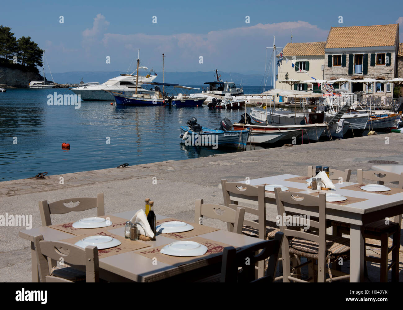 Waterfront Taverna Tabellen im malerischen Hafen von Loggos, Paxos, die Ionischen Inseln, griechische Inseln, Griechenland, Europa Stockfoto