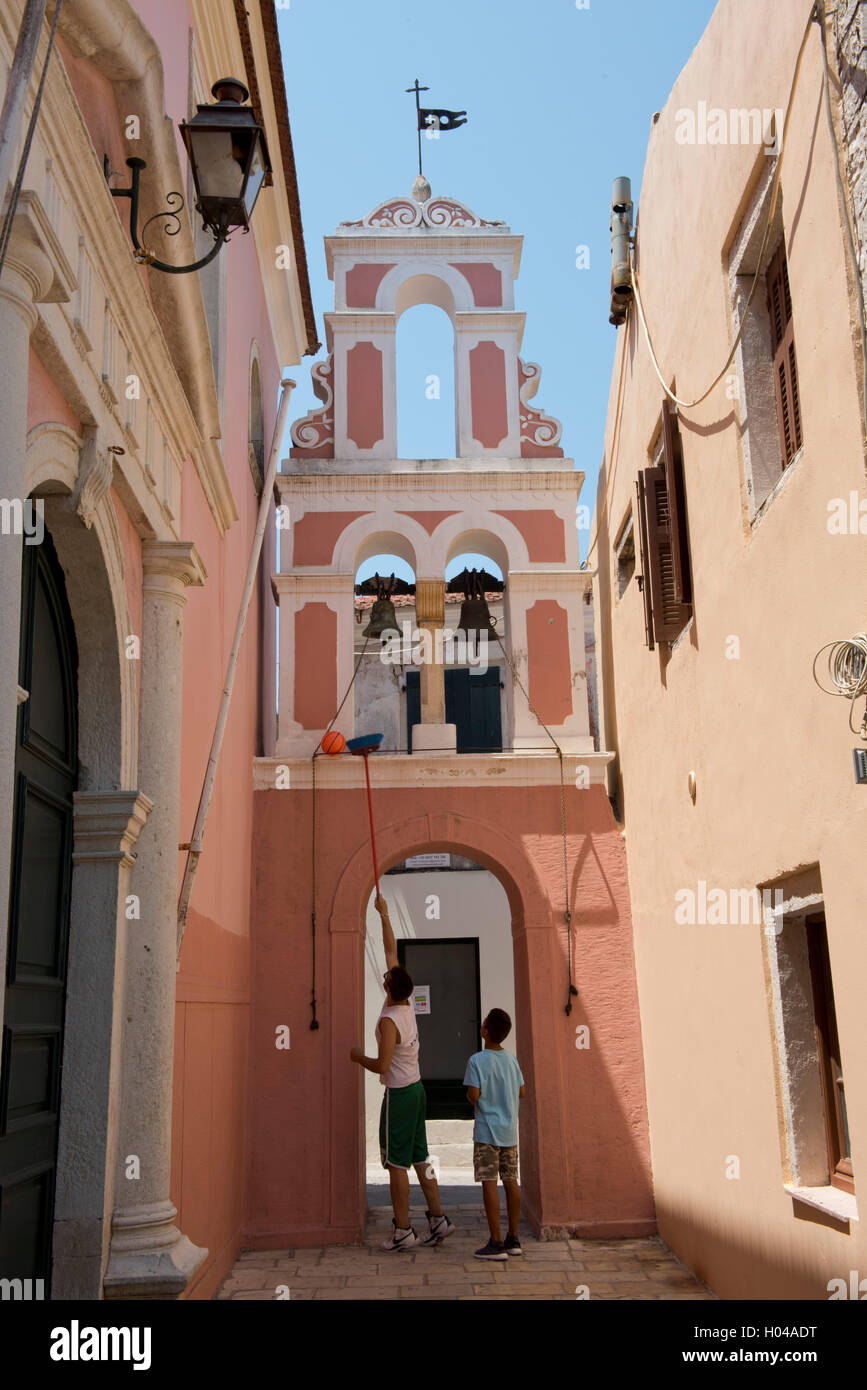 Jungen in Gaios Abrufen einer Kugel von Bell Tower von Agios Triada auf der Insel Paxos, die Ionischen Inseln, die griechische Insel Stockfoto
