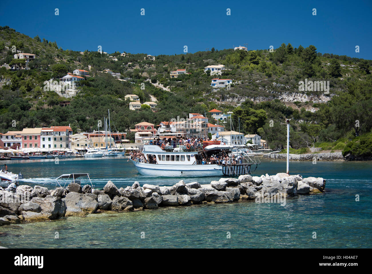 Eine Rechtskurve Boot voller Touristen gehen in den Hafen von Gaios auf der Insel Paxos, die Ionischen Inseln, die griechischen Inseln, Griechenland Stockfoto