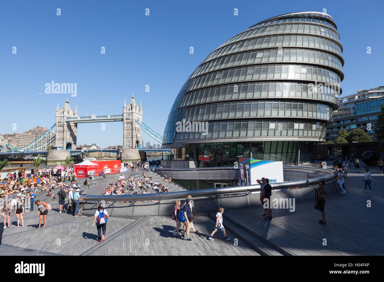 Massen von Touristen genießen die Sonne außerhalb der Glaskuppel des Rathauses in London. Stockfoto Massen von Touristen genießen die Sonne außerhalb der Glaskuppel des Rathauses in London. Stockfoto