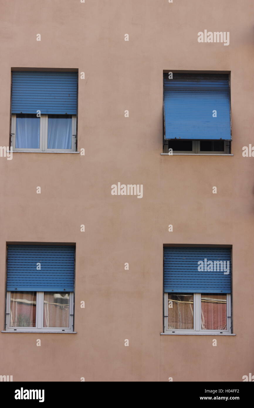 Blaue Fensterläden auf hellen rosa Gebäude, Fensterläden, Gebäude, Wand mit Fenstern, Rom, Roma Stockfoto