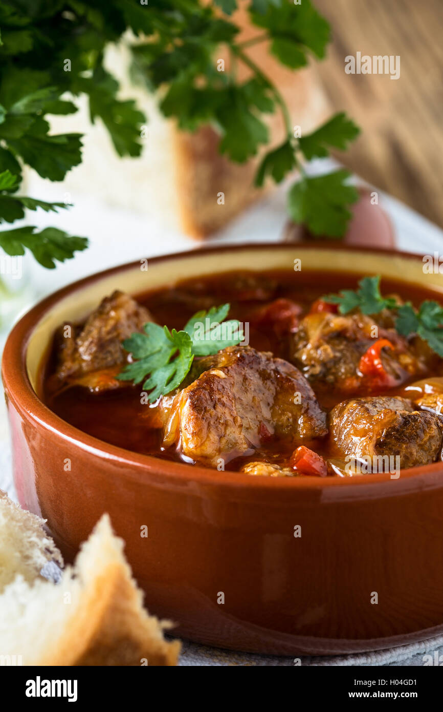 Fleisch-Eintopf in Keramiktopf. Traditionelles ungarisches Gulasch Stockfoto