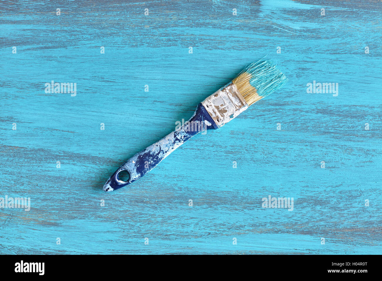 Schmutzige Pinsel mit blauer Farbe auf einem Holzbrett. Stockfoto