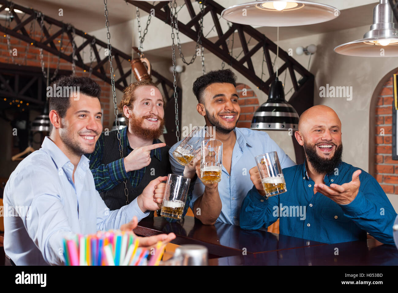 Man Gruppe In Bar am Counter Bestellung Barkeeper, Mix Rennen fröhlich Freunde stehen leere Biergläser halten Stockfoto