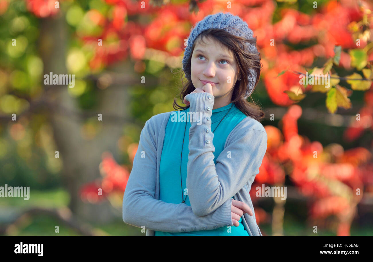 Mädchen denken in der Natur auf Grund des Herbstes Stockfoto
