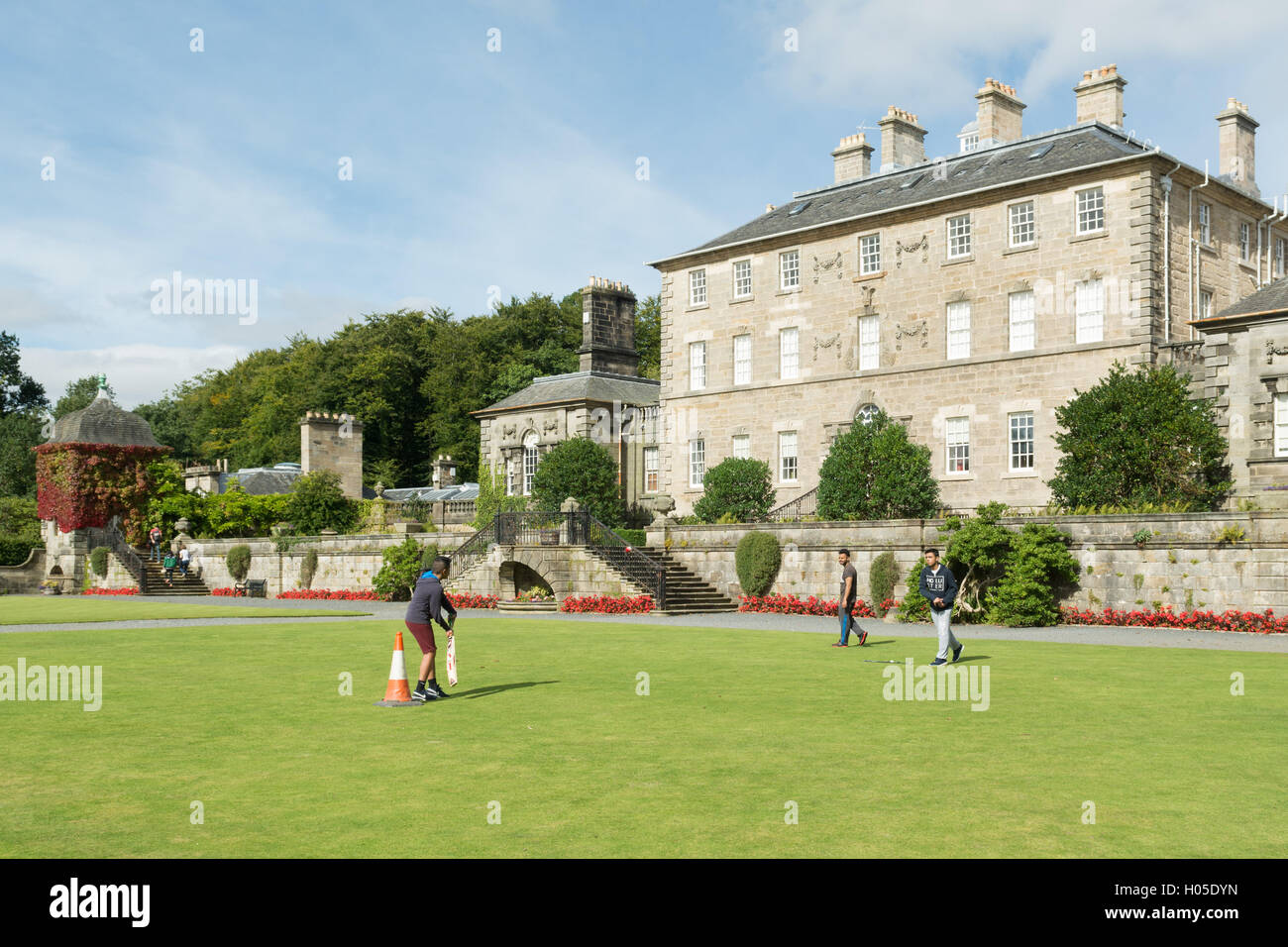 Spielen Sie Kricket auf Rasen am Eingang des Pollok House, Pollok Country Park, Glasgow, Schottland Stockfoto
