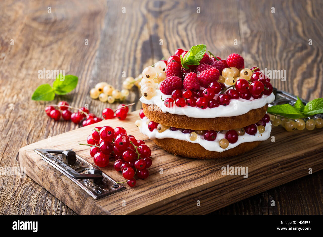 Selbst gemachter Butter Torte mit gepeitschter Creme Belag auf rustikalen Holztisch Stockfoto
