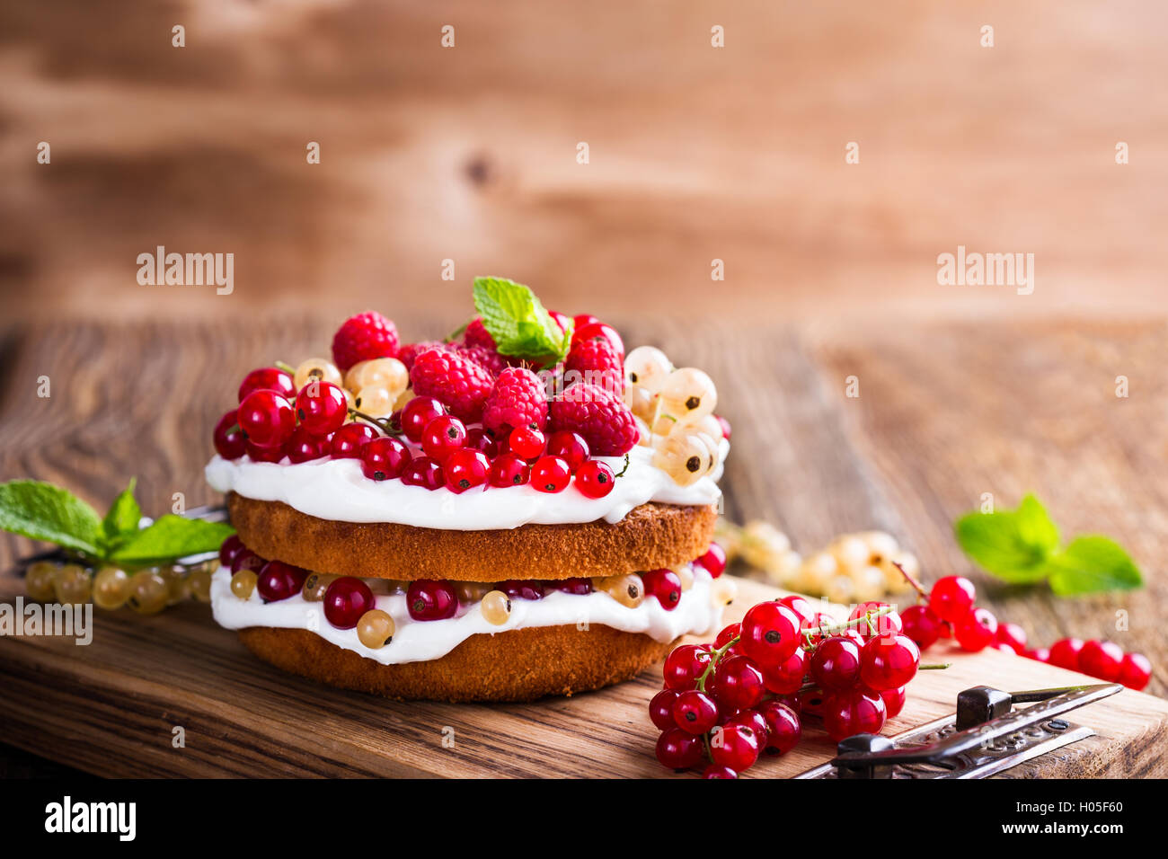 Selbst gemachter Butter Torte mit gepeitschter Creme Belag auf rustikalen Holztisch Stockfoto