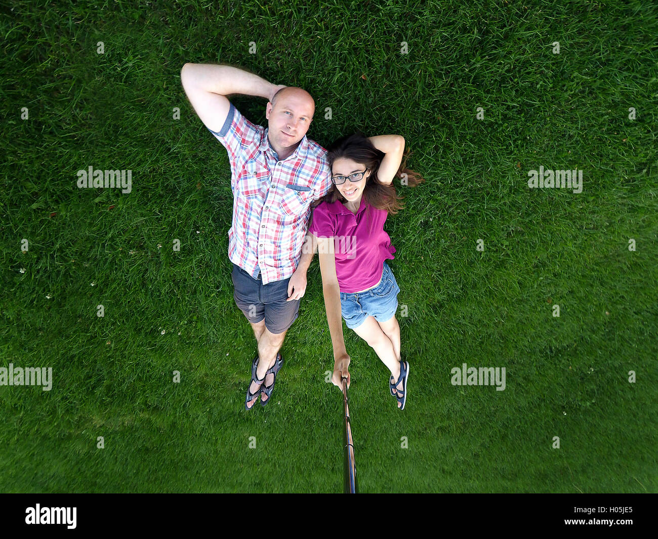 liebenden paar Mann und Frau liegt auf dem grünen Rasen Stockfoto