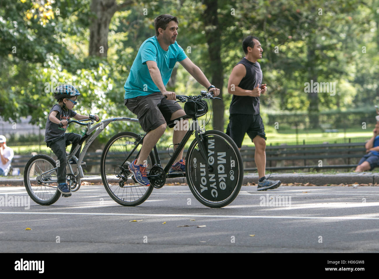 Ein Mann und sein Sohn sind im Central Park Reiten. Stockfoto
