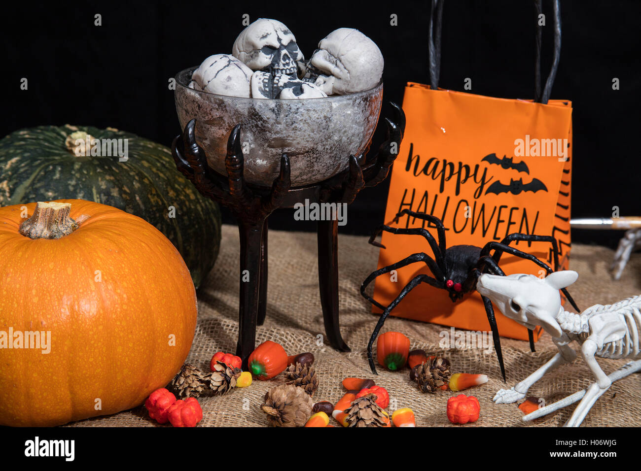 Tisch voll mit Halloween-Süßigkeiten und Dekoration mit Spinnen, Skelette und Kürbisse Stockfoto