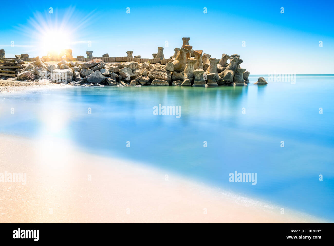 Langzeitbelichtung Szene mit Sonnenaufgang über einem Strand Wellenbrecher Struktur in Gura Portitei Black Sea Resort, Rumänien Stockfoto