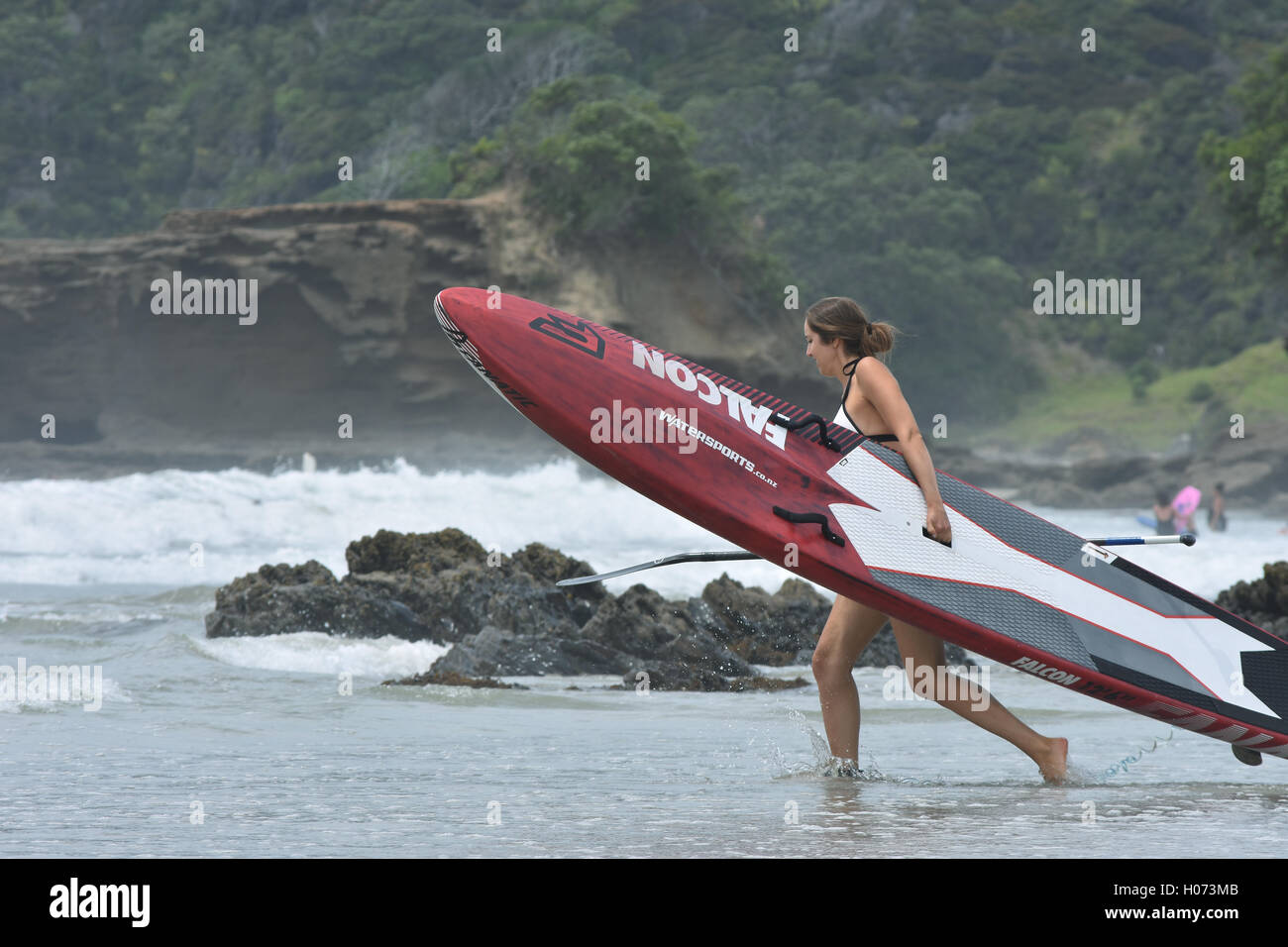 Junge Frau, die versucht Paddling Stockfoto