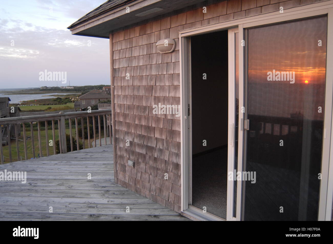 Sunset Veranda Strand Cottage Glas Reflexion einsam reflektierenden friedliche Stimmung Outer Banks Haus Hütte untergehende Sonne Ton Stockfoto
