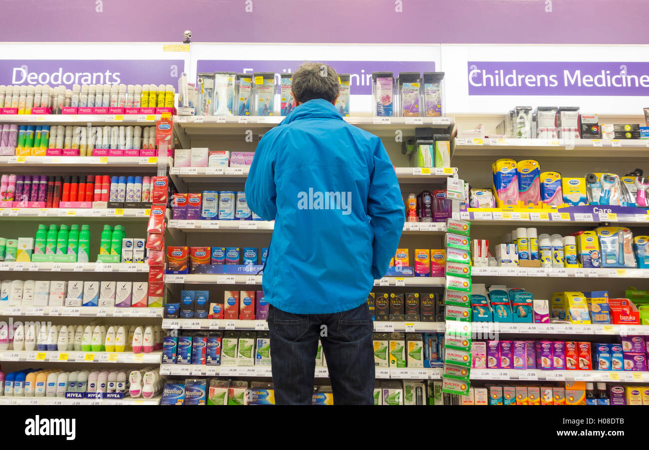 Mann sucht auf Familienplanung (Kondome) Display im Supermarkt. UK Stockfoto