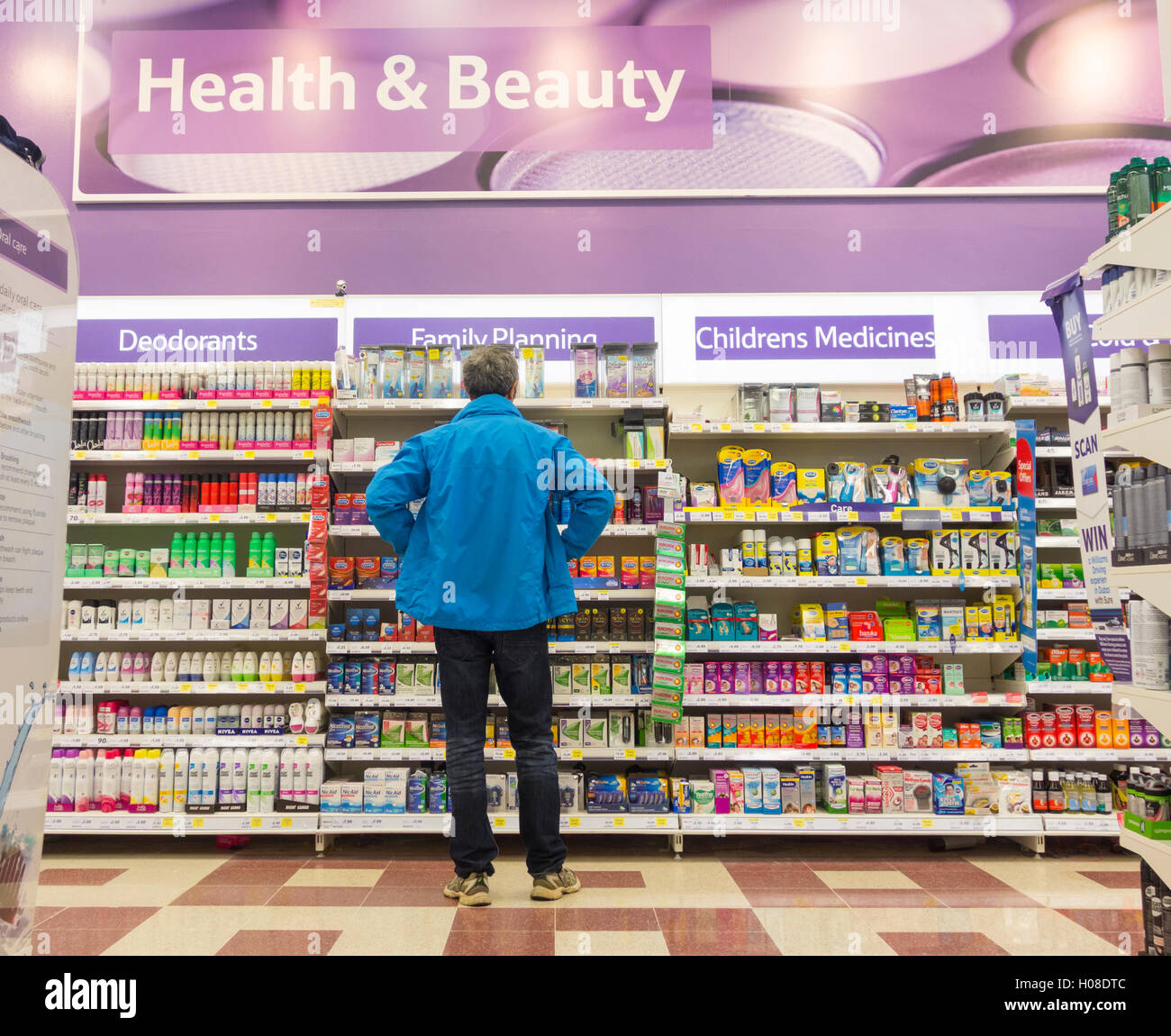 Mann an Familienplanung suchen (Kondome) Display im Tesco Supermarkt. Großbritannien Stockfoto