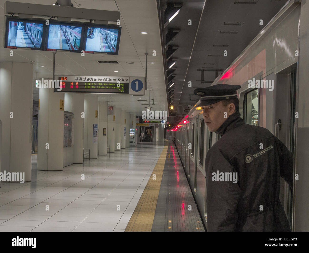 Eisenbahn-Guard prüft eine leere Plattform vor Signalisierung ok für den Zug zum Bahnhof verlassen. japanische s trainieren Tokio Stockfoto