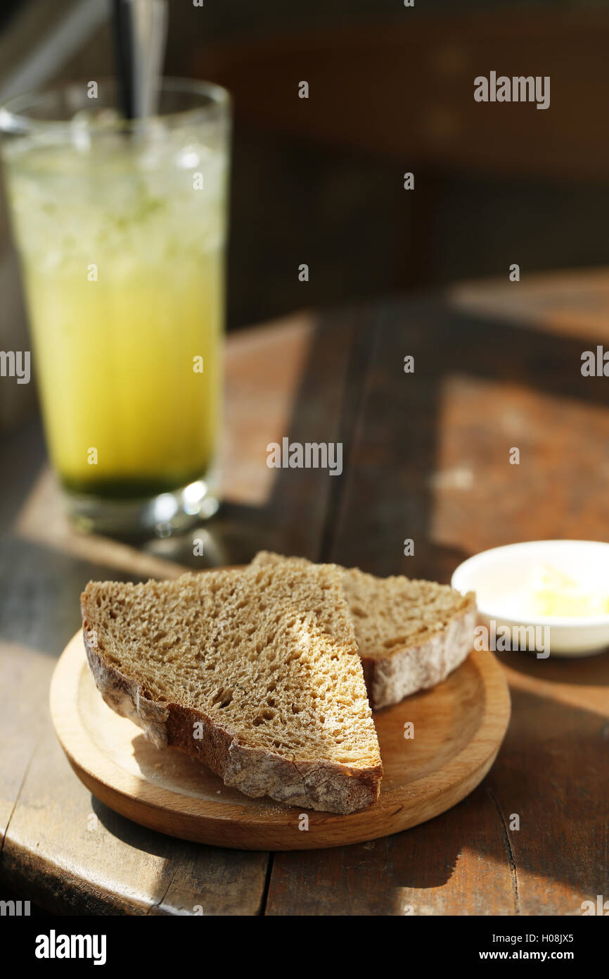 Schwarzes Brot auf Holzplatte mit saftigen Früchten auf den Tisch Stockfoto