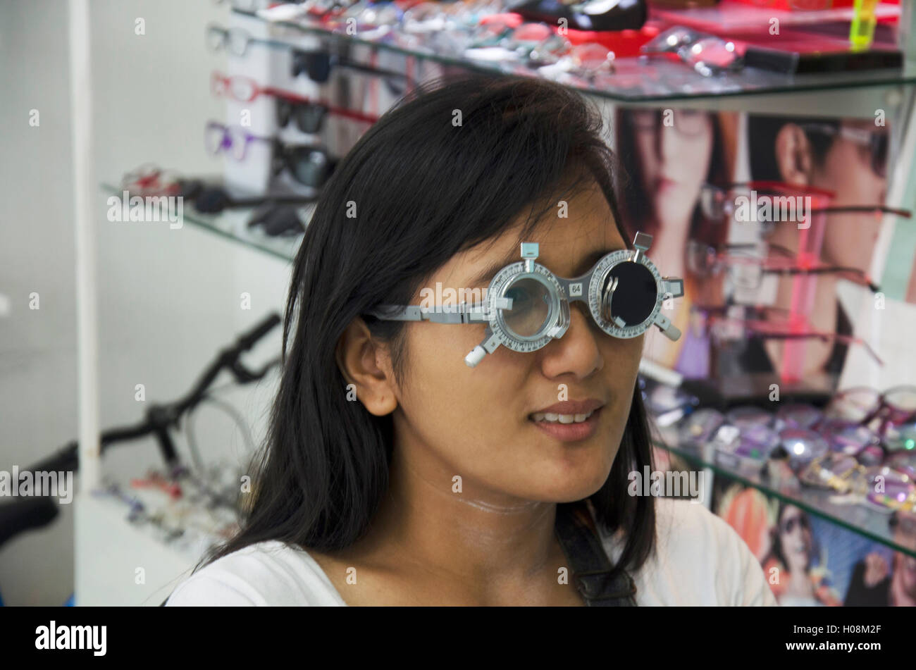 Thai Frau Scheck optische Sehtest oder Sehschärfe für die Herstellung von Brillen vom Optiker Sehvermögen testen und Pflege bei optischen Shop am Juli Stockfoto