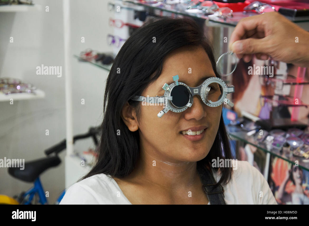 Thai Frau Scheck optische Sehtest oder Sehschärfe für die Herstellung von Brillen vom Optiker Sehvermögen testen und Pflege bei optischen Shop am Juli Stockfoto