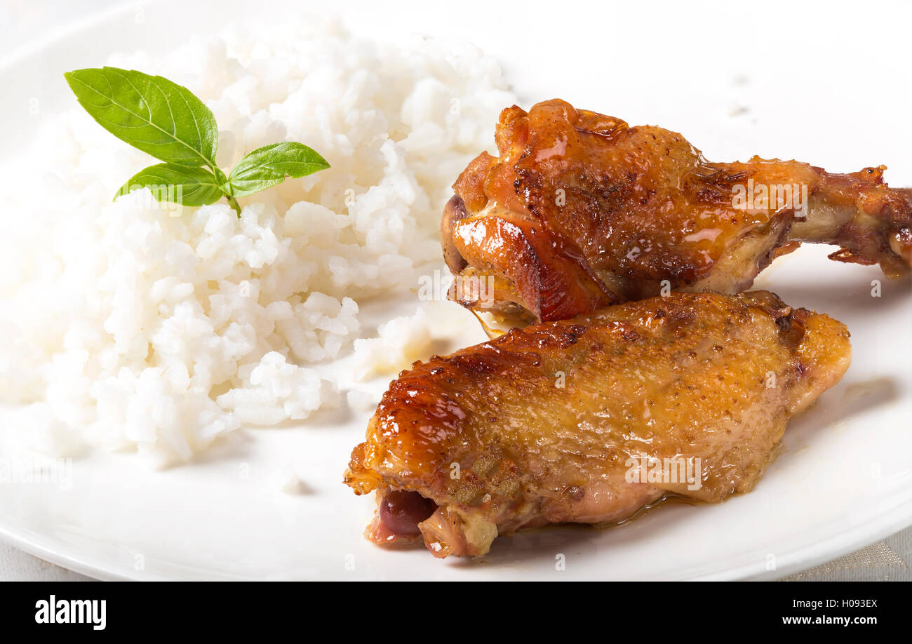Gegrillte Chicken wings mit Reis auf einem weißen Teller Stockfoto