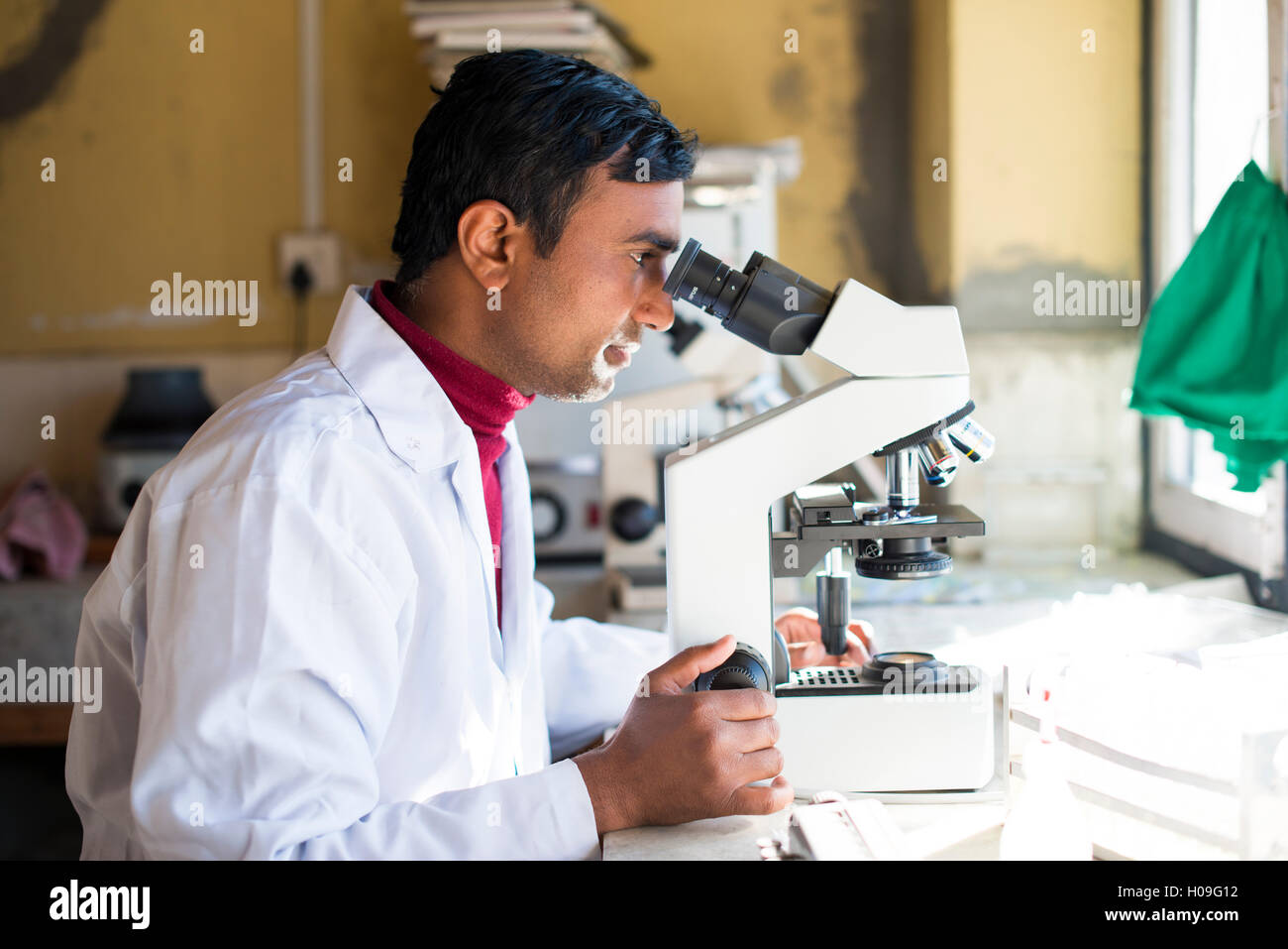 Eine Laborantin arbeiten in einem Labor in einem kleinen Krankenhaus in Nepal befasst sich mit einem Mikroskop, Jiri, Solu Khumbu, Nepal, Asien Stockfoto