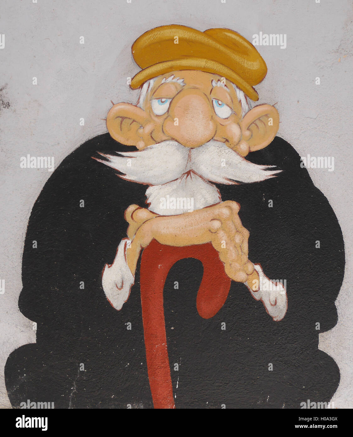 Wandkunst freundlicherweise Alter Mann mit weißem Bart und großen Schnurrbart, in schwarzen Klamotten und Baskenmütze, stützte sich auf Spazierstock sitzen Stockfoto